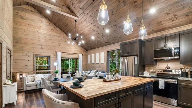 A spacious kitchen with wooden cabinets, a central island, and modern appliances. - Kids LOVE This Cabin! Racing Games + Hot Tub (Sevierville)