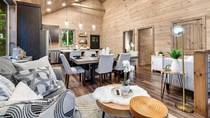 A cozy cabin interior with a dining area, kitchen, and seating space. - Kids LOVE This Cabin! Racing Games + Hot Tub (Sevierville)