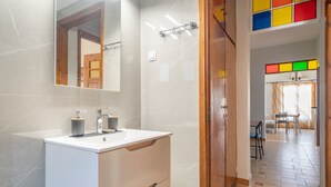 A bathroom with a white sink, mirror, and wooden cabinets. - Apartment 'Mati Guest House' with Sea View, Wi-Fi and Air Conditioning (Νυδρί)