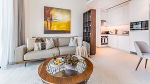 A modern living room with a sofa, coffee table, and artwork on the wall. - Balcony Facing the Marina with Partial Sea Views, Steps from the Beach (Dubai)
