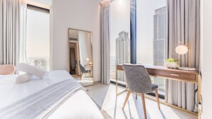 A modern hotel room with a large bed, a desk with a chair, a mirror, and a view of tall buildings. - Balcony Facing the Marina with Partial Sea Views, Steps from the Beach (Dubai)