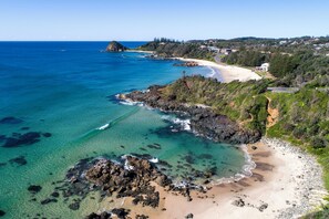 A coastal landscape with clear blue waters, a sandy beach, and rocky outcrops. - Rocky Beach Retreat - Apartment - Sleeps 6 (Port Macquarie)