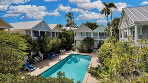 A pool surrounded by houses with a clear sky. - **WINDWARD WAVES @ OLD TOWN** Cottage by Duval + Last Key White Glove Service... (Key West)
