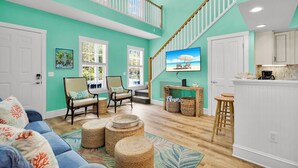 A spacious living area with a high ceiling, a staircase, and a kitchen area. - **WINDWARD WAVES @ OLD TOWN** Cottage by Duval + Last Key White Glove Service... (Key West)