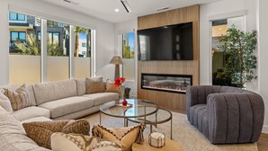A modern living room with a sofa, armchair, and a fireplace. - Simply Paradise: Steps to Desert Color Lagoon + Beaches (St. George)