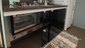 Una cocina compacta con estufa a gas, horno y refrigerador.