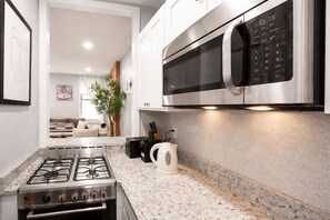 Een moderne keuken met een gasfornuis, een magnetron en een aanrecht.