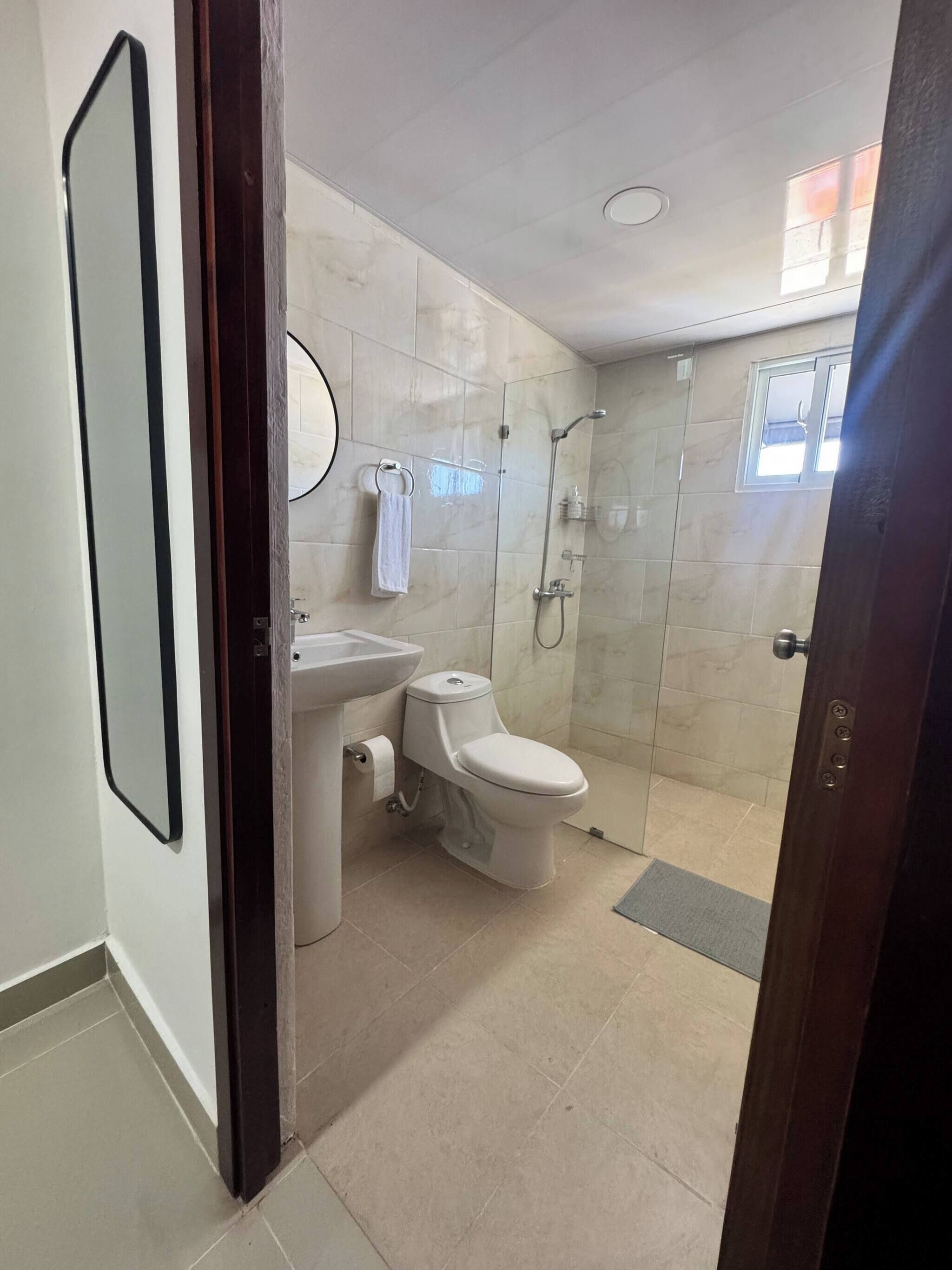 Une salle de bain moderne équipée de toilettes, d’un lavabo et d’une douche.