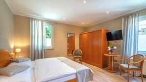A hotel room with a bed, a chair, a TV, and a desk. - Landgasthof Hieren Mühle (Boppard)