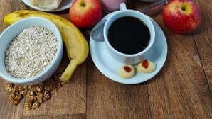A breakfast setting with various food items including bread, apples, a banana, oatmeal, and a cup of coffee. - Hotel Oliveira 44 (Goiânia)