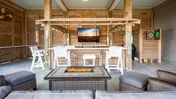Un interior de madera con una zona de bar, asientos y una chimenea.