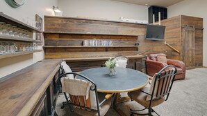 A cozy dining area with a round table, chairs, and a bookshelf. - Guest house escape in the trees (Angel Fire)
