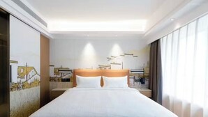 Une chambre d’hôtel avec un grand lit, une tête de lit et une fresque murale.