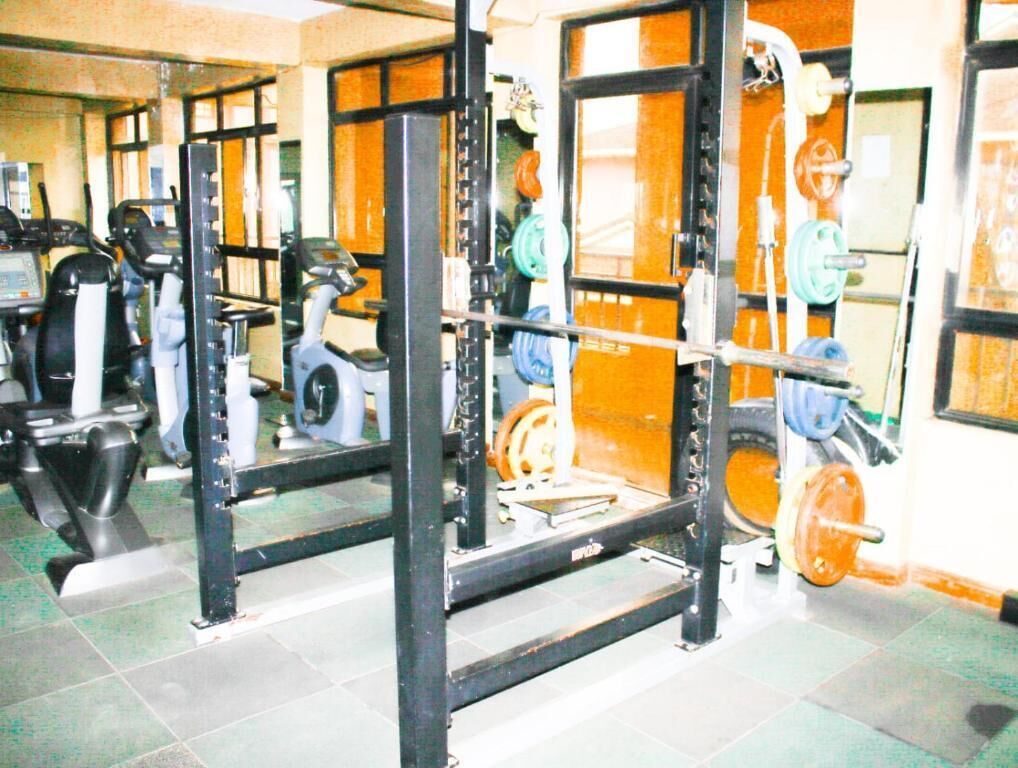 A gym with weightlifting equipment, treadmills, and exercise machines.