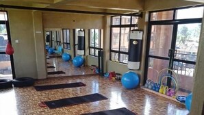 Ein geräumiger Fitnessraum mit Trainingsmatten, blauen Gymnastikbällen und Sandsäcken.
