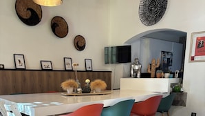 Cozinha moderna com ilha central, piso de madeira e cadeiras coloridas.