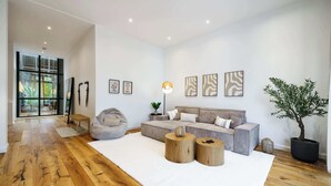 Un salon moderne avec un grand canapé, une table basse et une plante en pot.
