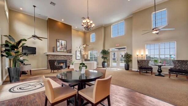 A spacious living room with a fireplace, a round dining table, and comfortable seating. - Global Luxury Suites in Abilene Texas (Abilene)