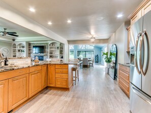 A spacious kitchen with wooden cabinets, granite countertops, and a stainless steel refrigerator. - Charming Countryside Home / Near Edmond & OKC (Arcadia)