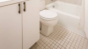 Un bagno con lavandino, water e vasca da bagno bianchi.
