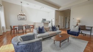 A spacious living room with a sofa, armchairs, a coffee table, and a dining area with chairs and a table. - The only 4 Bedroom Apartment w/ Roofdeck in Boston!  8min from Fenway Park, close to universities! (Boston)