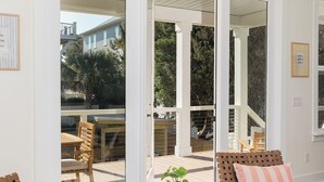Un salon moderne doté d’une grande porte-fenêtre coulissante donnant sur un espace patio extérieur.