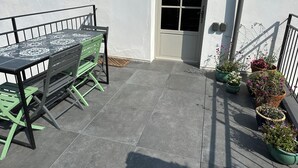 A patio with a table and chairs, a door, and potted plants. - Kermaria Trois Fontaines Deluxe Studio Suite, by the Bois d’Amour Pont Aven (Pont-Aven)