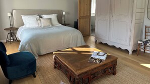 A bedroom with a bed, bedside tables, a wardrobe, a chair, and a coffee table. - Kermaria Trois Fontaines Deluxe Studio Suite, by the Bois d’Amour Pont Aven (Pont-Aven)