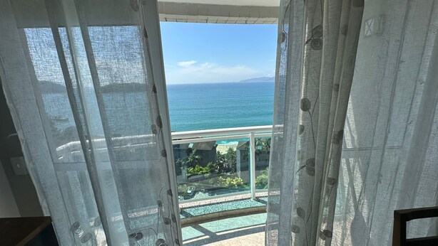 Un balcon avec vue sur l’océan et une piscine.