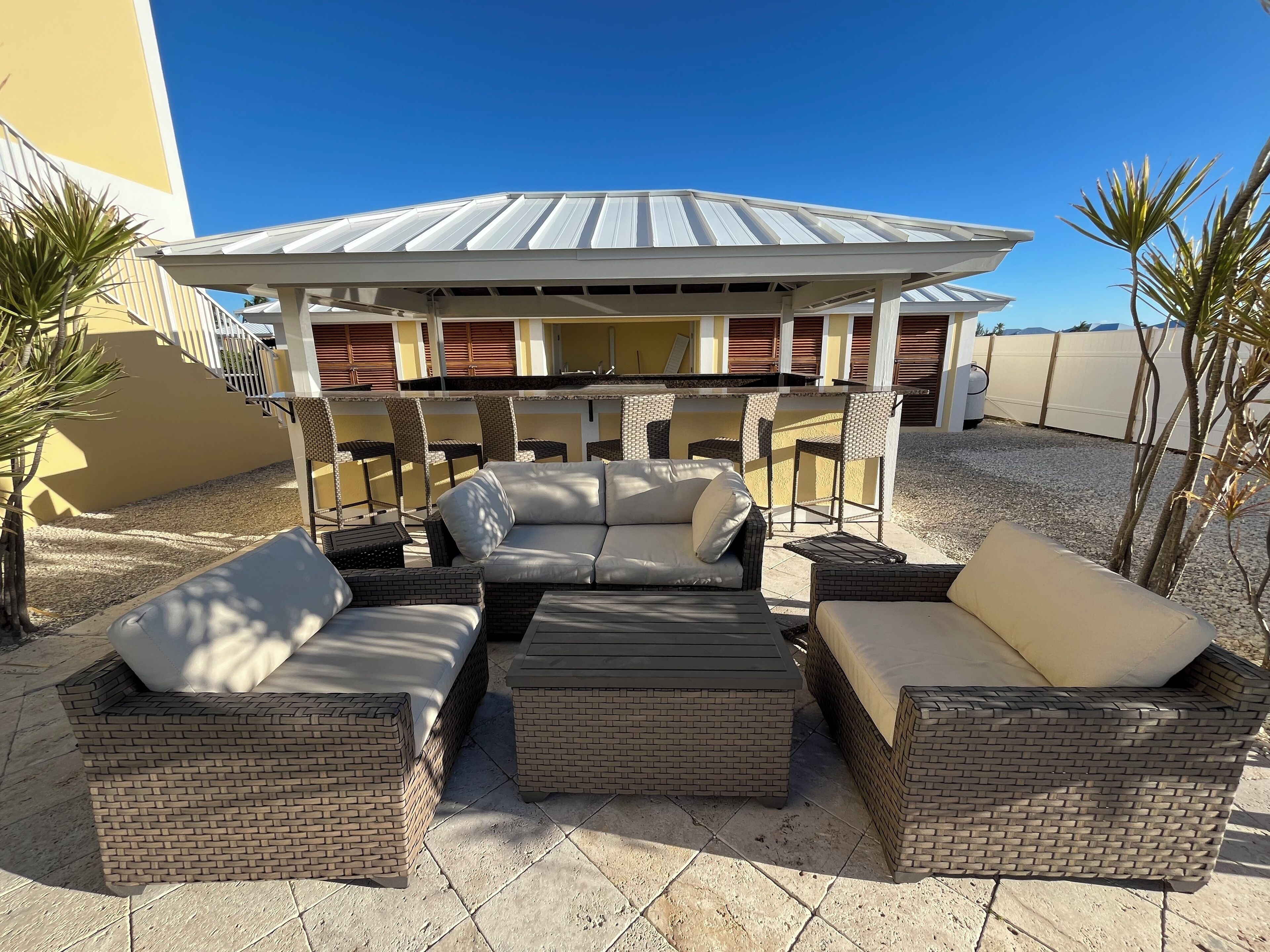 An outdoor seating area with wicker furniture and a covered patio.