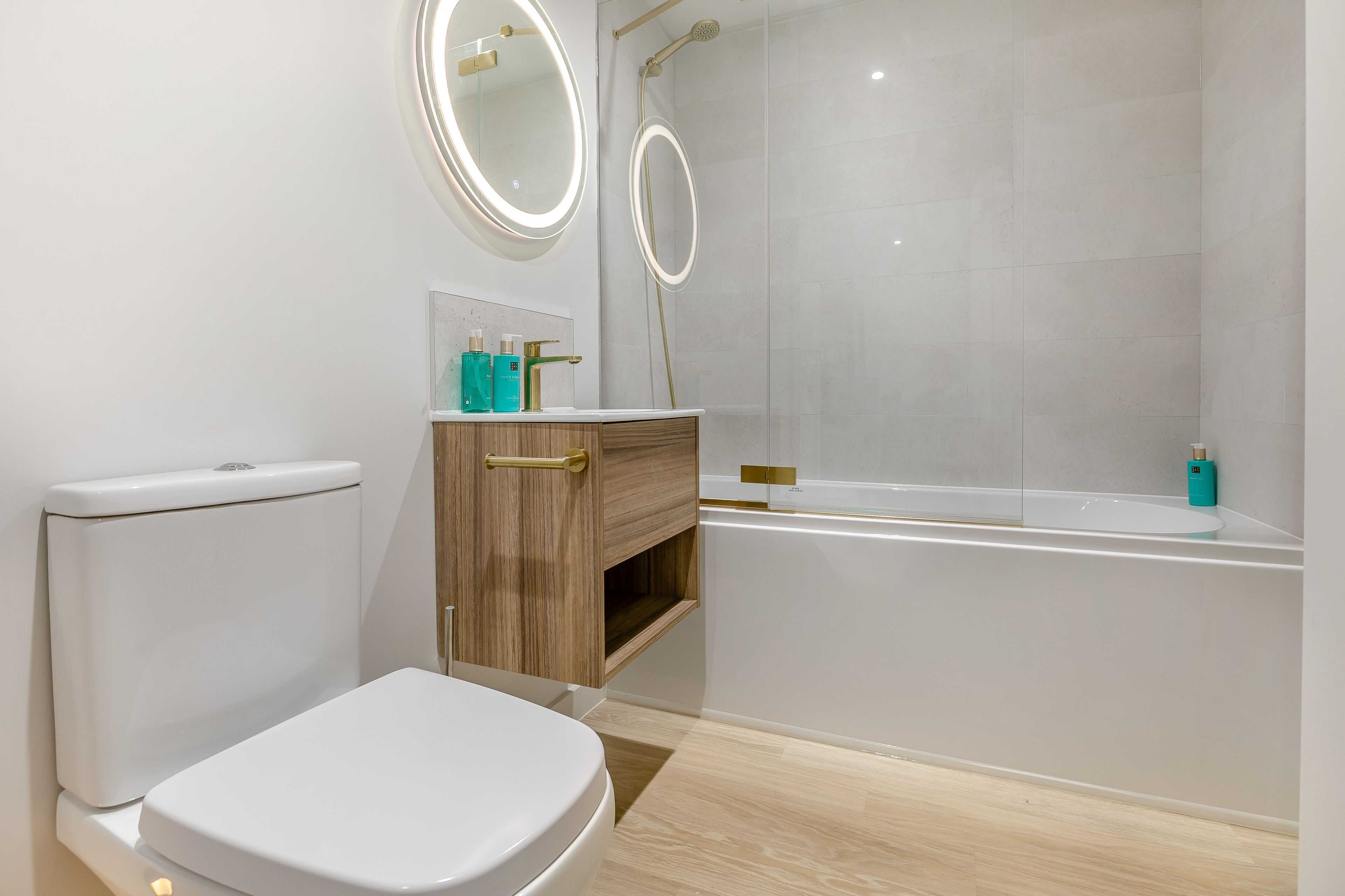 Ein modernes Badezimmer mit Toilette, Waschtisch und Badewanne.