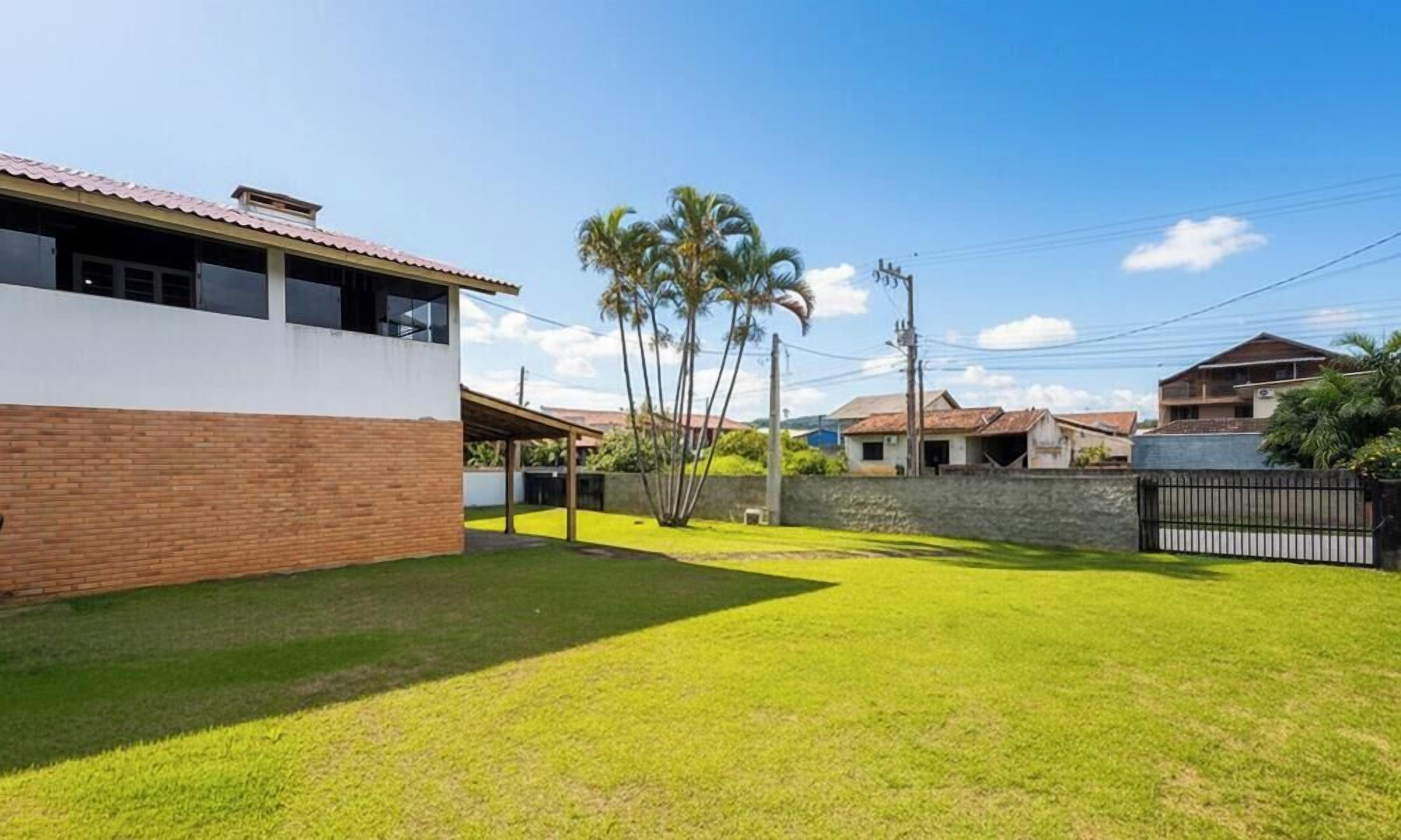 A residential area with a modern house, a well-maintained lawn, and a clear sky.