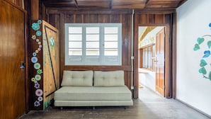 A wooden room with a bench, a window, and a door with floral decorations. - Large 3-bedroom House in Penha Sel0068 (Penha)