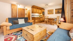 Una sala de estar acogedora con un sofá, una mesa de centro de madera y un comedor con una mesa y sillas.