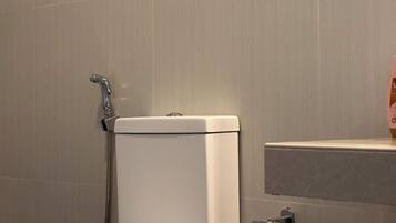 Ein modernes Badezimmer mit Toilette, Dusche und Handtuchhalter.