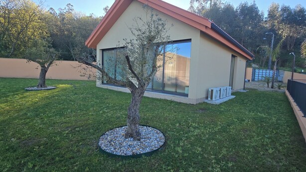 A modern building with a red roof, large windows, and a well-maintained lawn with a tree. - 6 holiday homes in the tranquillity of nature near Barcelos (Roriz)