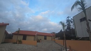 A courtyard with a cobblestone ground, a building with a red-tiled roof, and a palm tree. - 6 holiday homes in the tranquillity of nature near Barcelos (Roriz)