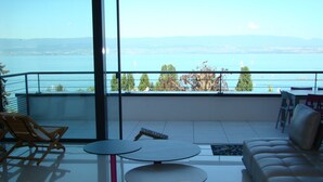 A balcony with a view of a body of water, a table, and seating. - Air-conditioned house 8 pers- 10km Evian -40km portes soleil- with parking lot (Thonon-les-Bains)