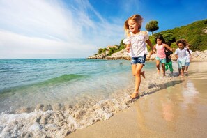 Eine Strandansicht mit klarem Wasser und einer felsigen Küste.