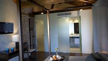 Una sala de estar moderna con televisor de pantalla plana, un comedor y una cocina visible a través de un acceso abierto.