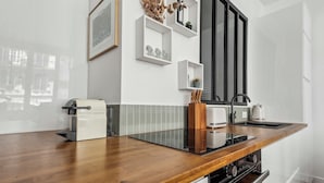 Una cocina moderna con encimera de madera, electrodomésticos integrados y muebles de cocina blancos.