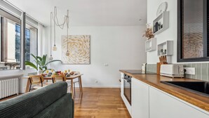Una cocina moderna con comedor, suelo de madera y un amplio ventanal.
