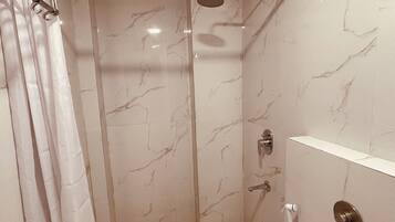 Habitación Deluxe | Baño | Ducha, artículos de higiene personal gratuitos, toallas y jabón