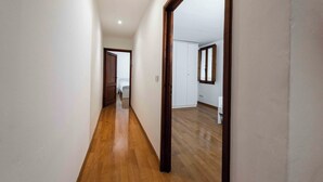 A narrow hallway with wooden flooring and white walls. - Old City Nest by MMega (Florence)