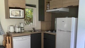 Kompakti keittiö, jossa on mikroaaltouuni, kahvinkeitin, leivänpaahdin ja astianpesukone.