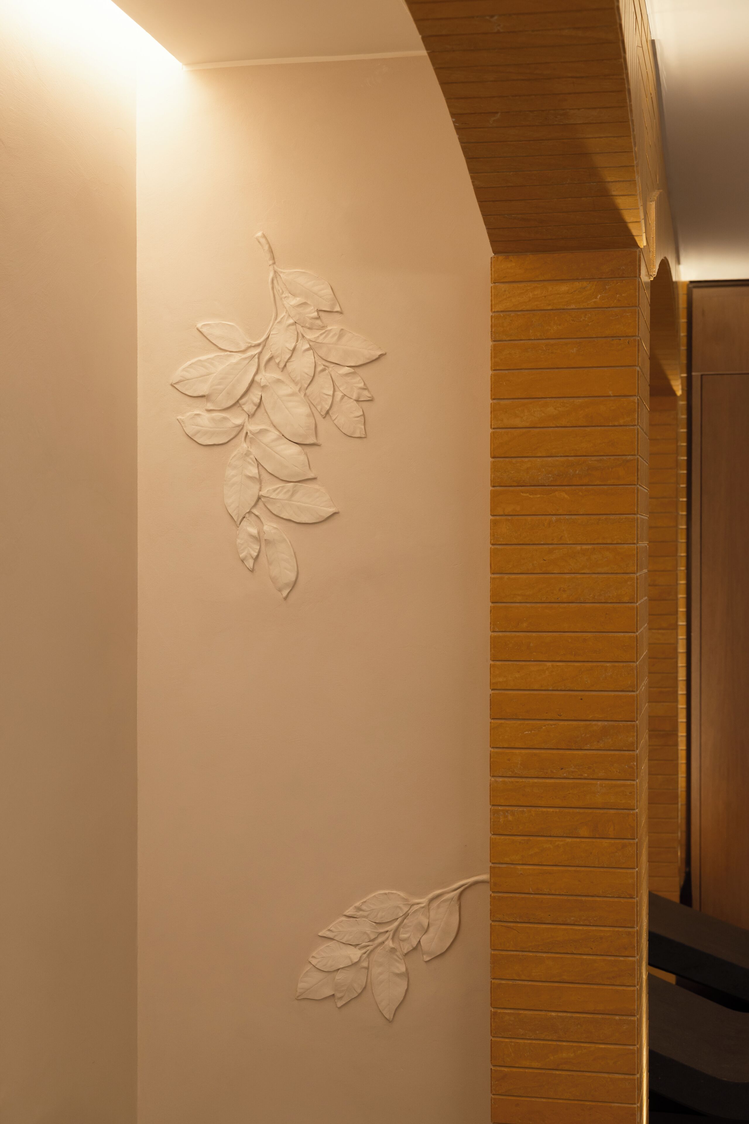 A wall with a leaf pattern and a wooden panel.