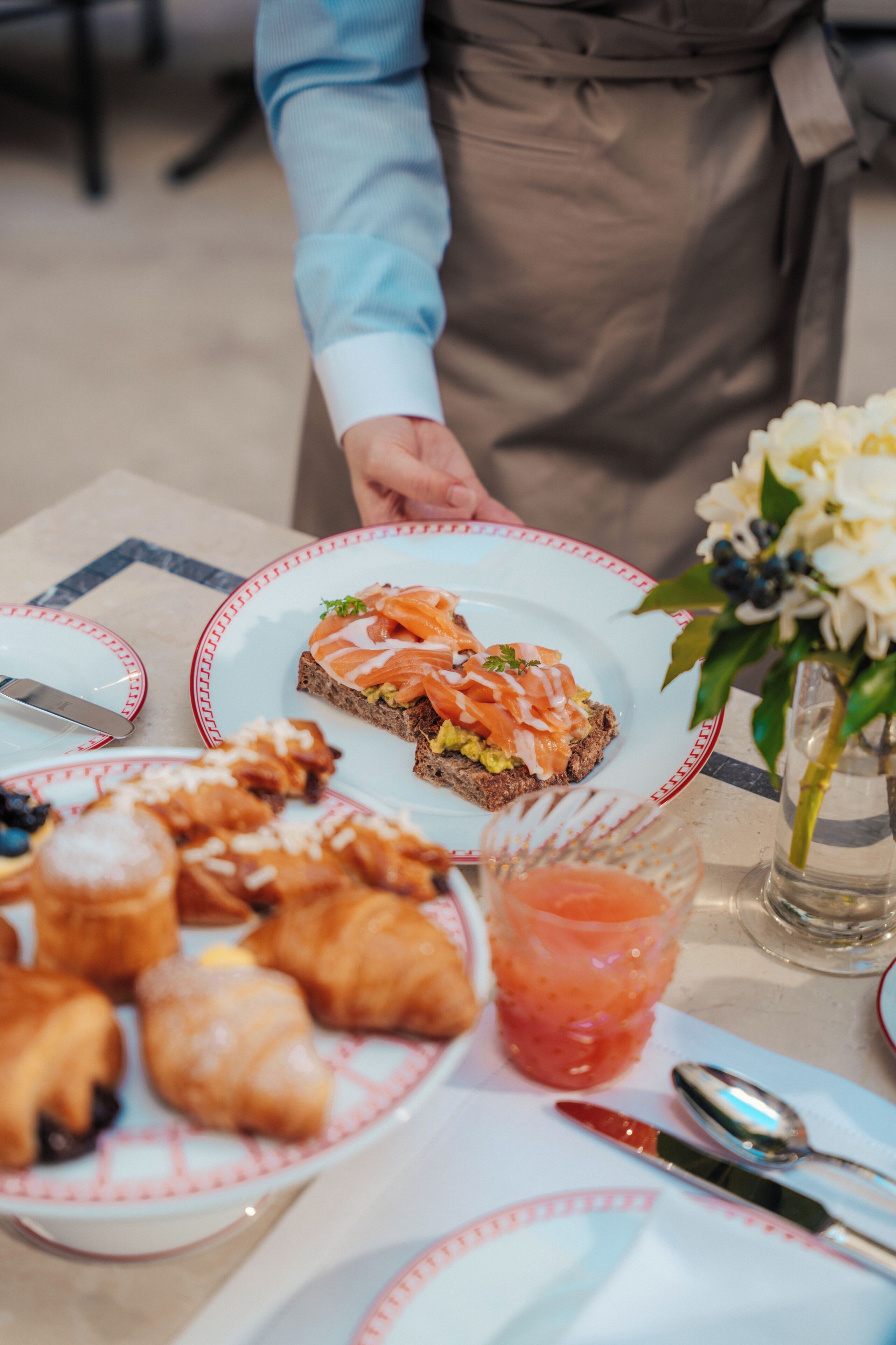 Ein Tisch mit Speisen, darunter Croissants und ein Sandwich mit Räucherlachs.