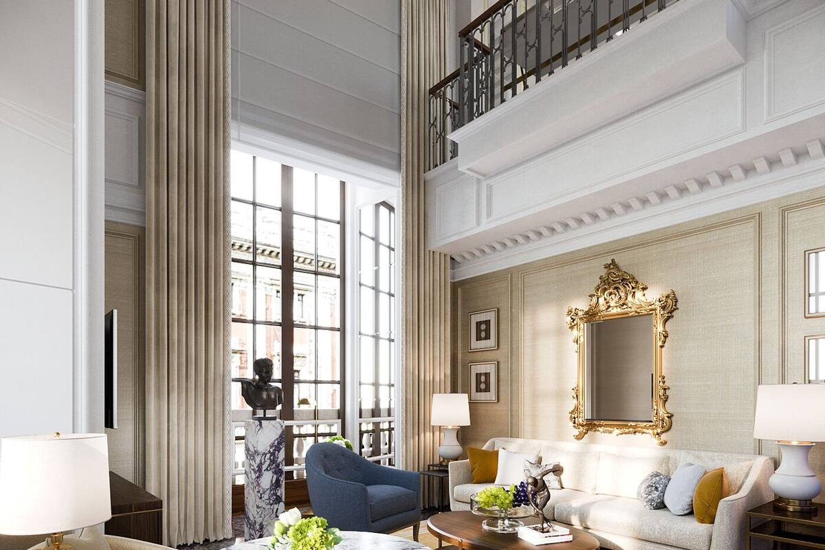 A spacious hotel lobby with a high ceiling, a grand staircase, and a large mirror.