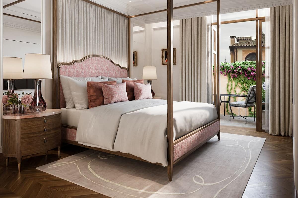 A four-poster bed with a wooden frame, a nightstand with a lamp, and a view of the outdoor balcony with plants.