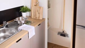 Et moderne køkken med indbygget mikroovn, vask og skærebræt i træ.